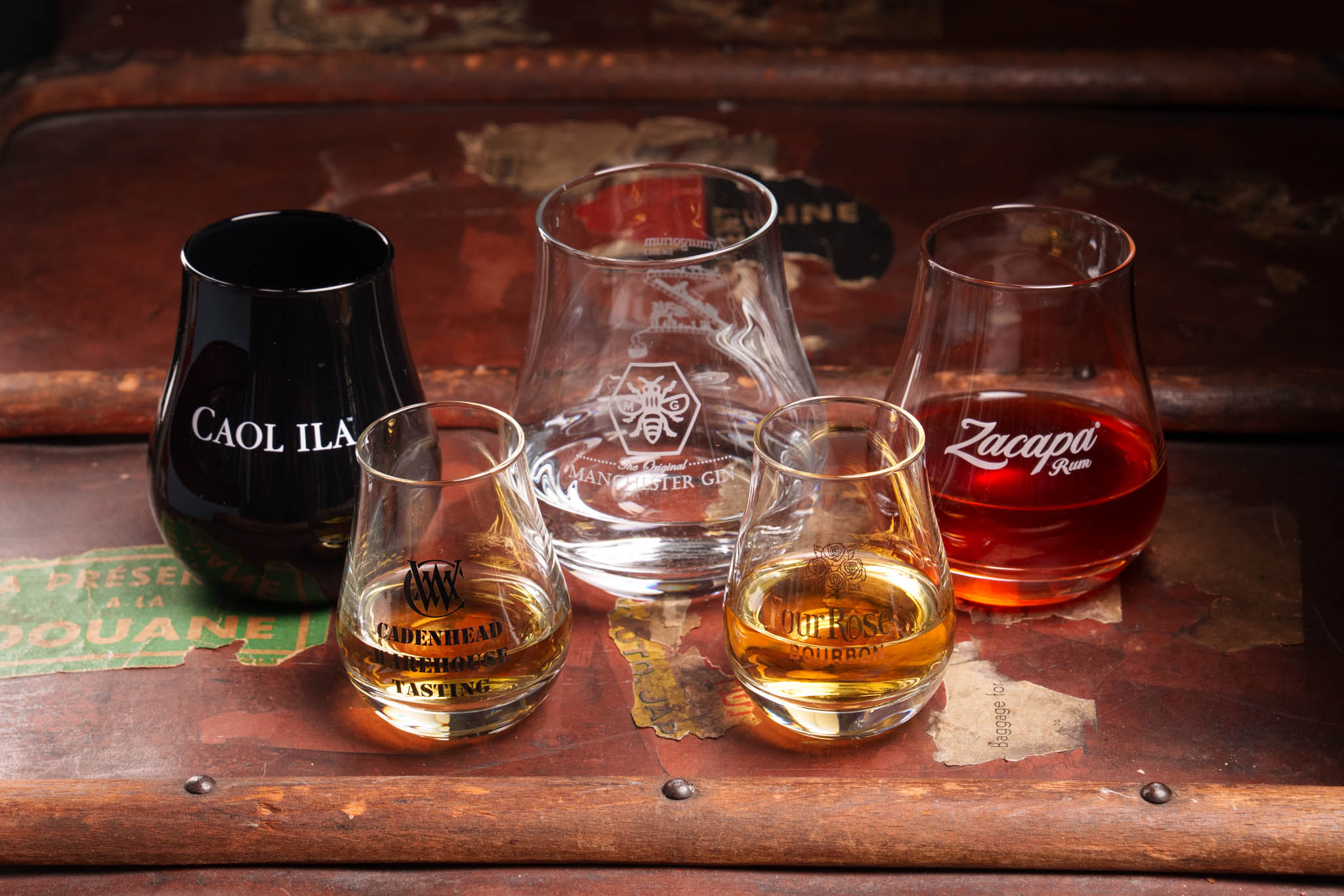 Various glassware on old steamer trunk whisky lifestyle photography Scotland