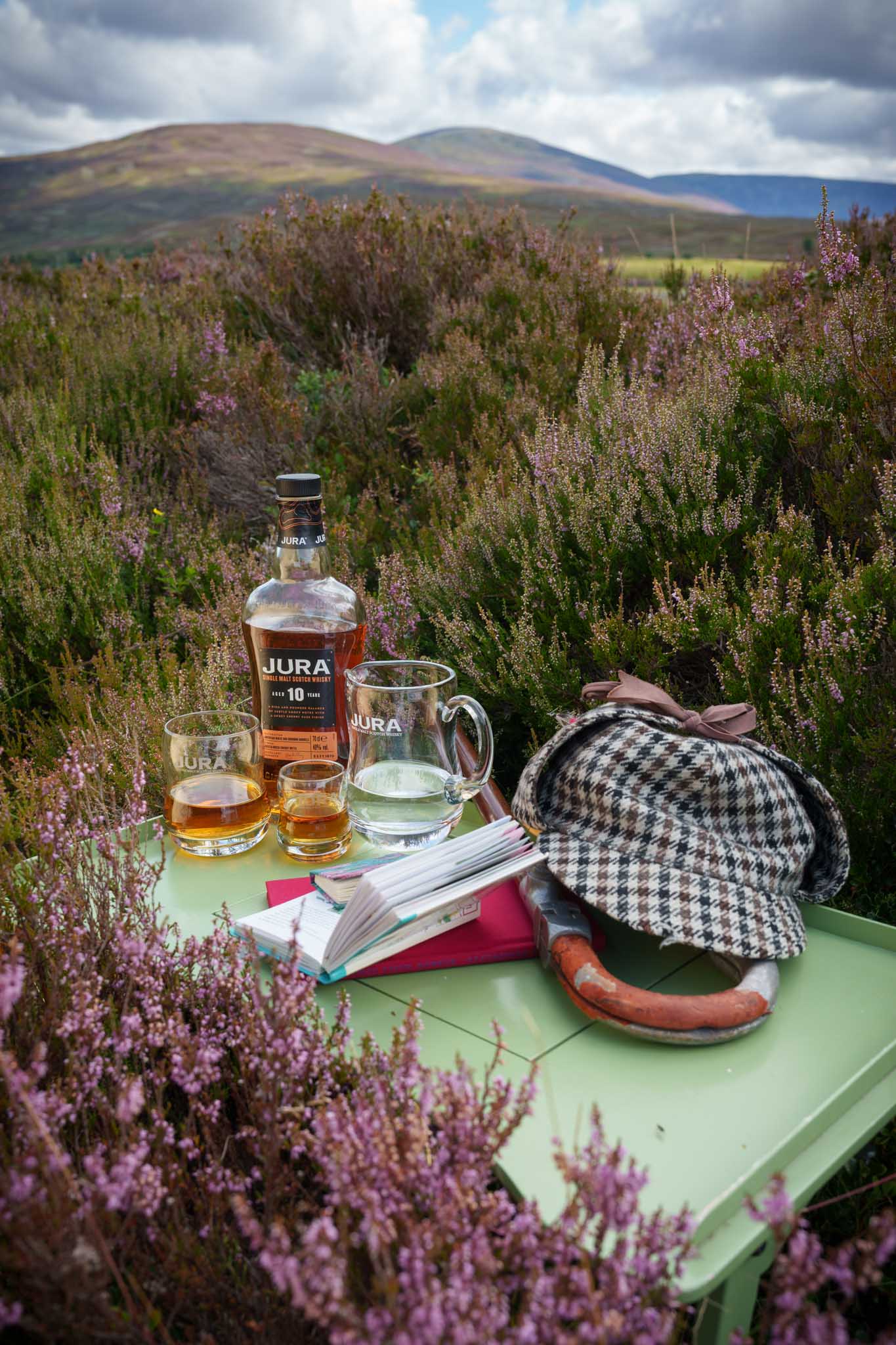 Jura whisky glasses on heather hillside – whisky lifestyle photography Scotland