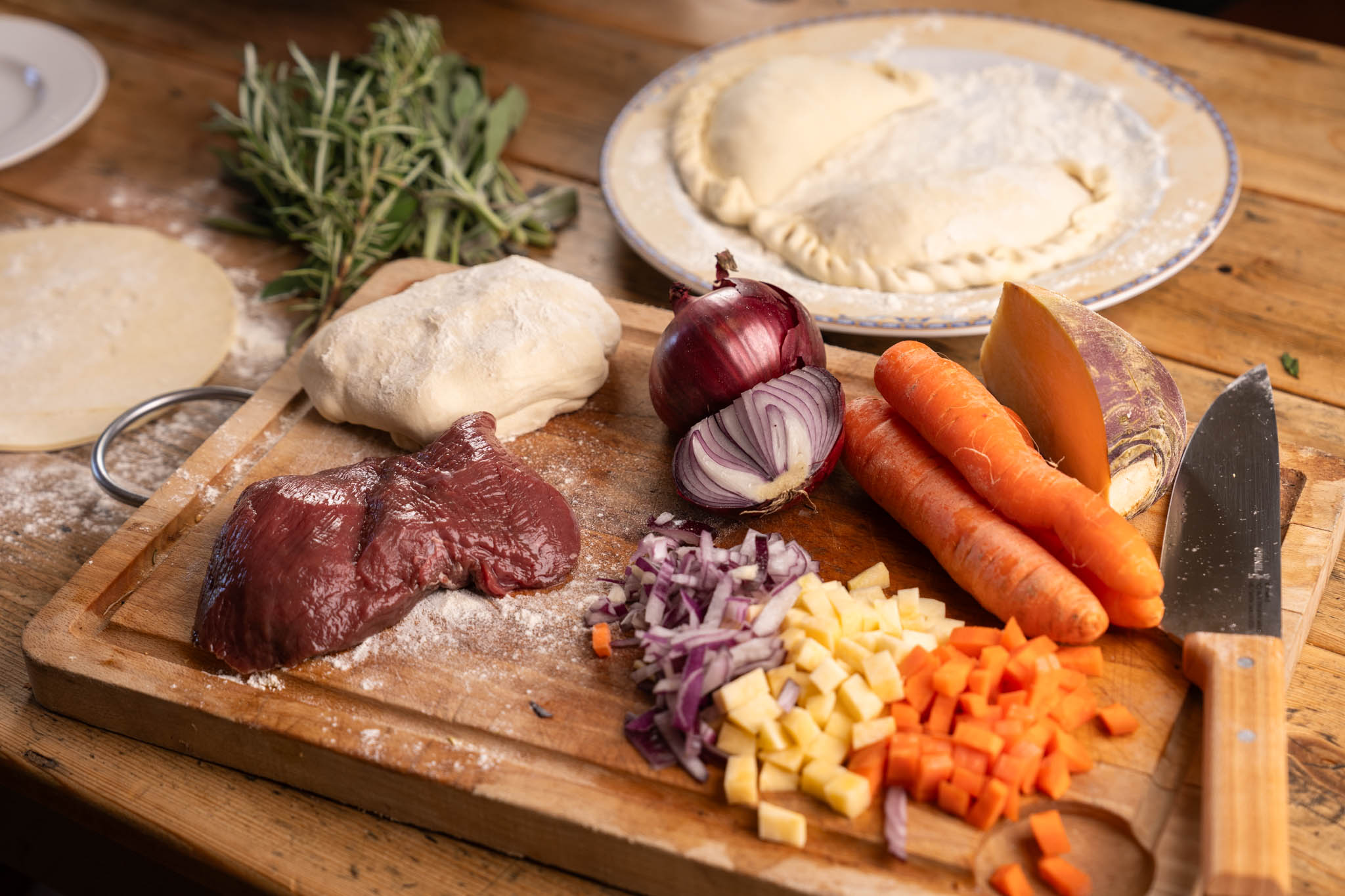 Raw venison, chopped vegetables and pastry laid out for a venison pasty recipe