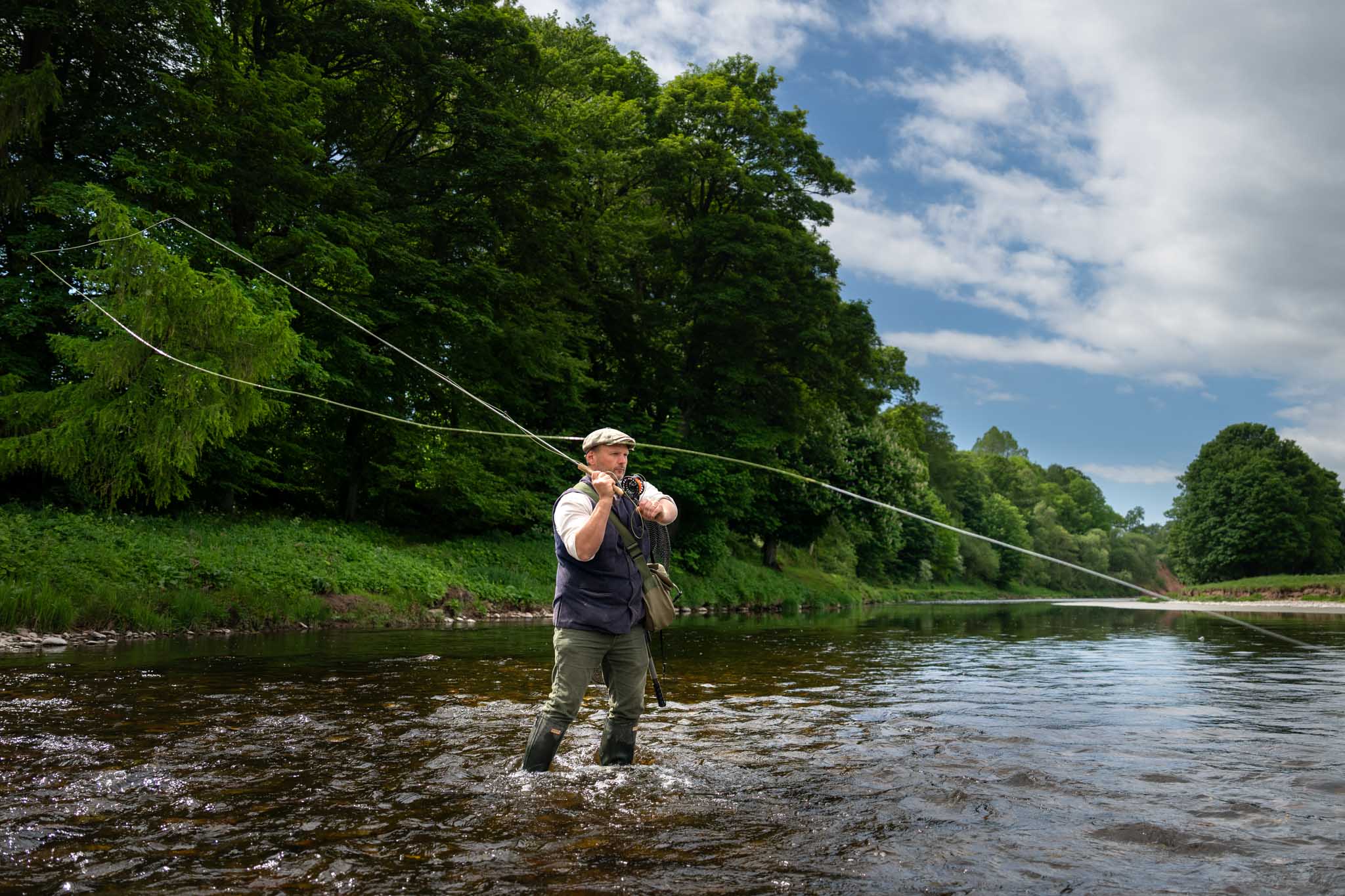 Tom Godber-Ford Moore fly fishing on the North Esk, wide shot with Spey cast in motion by fishing photographer Scotland