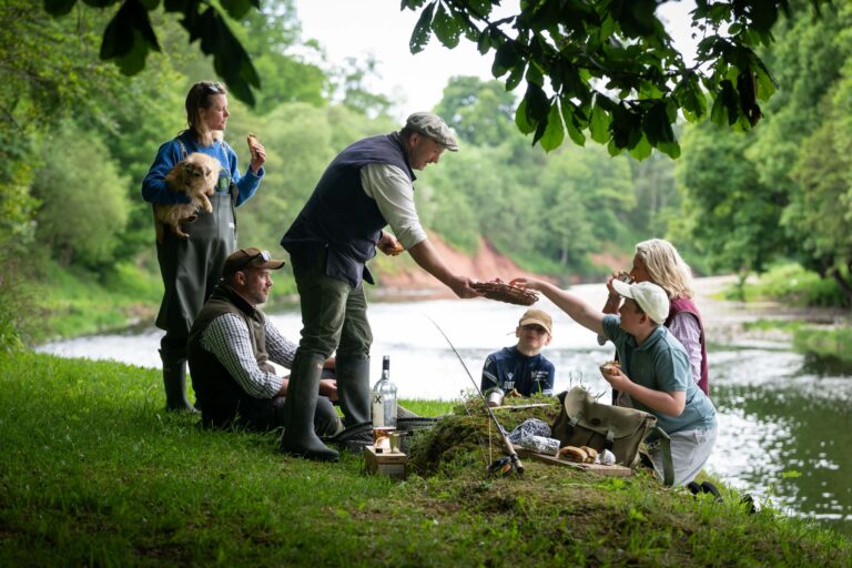 Family picnic on the riverbank, sharing pasties and pan bagnat by the North Esk